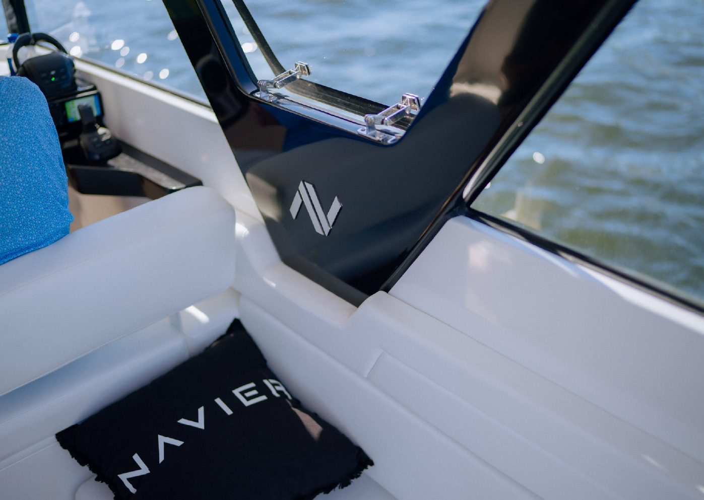 Navier boat interior with embroidered NAVIER cushion and metal brand mark