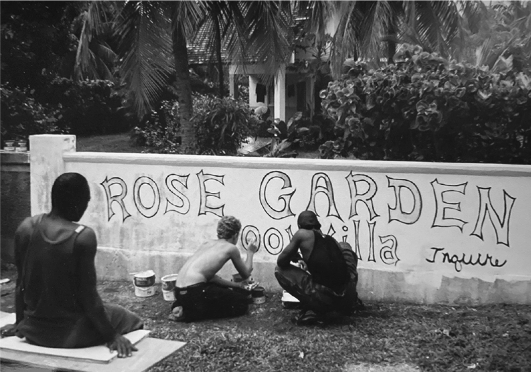 People painting the Rose Garden Villa wall sign in Jamaica